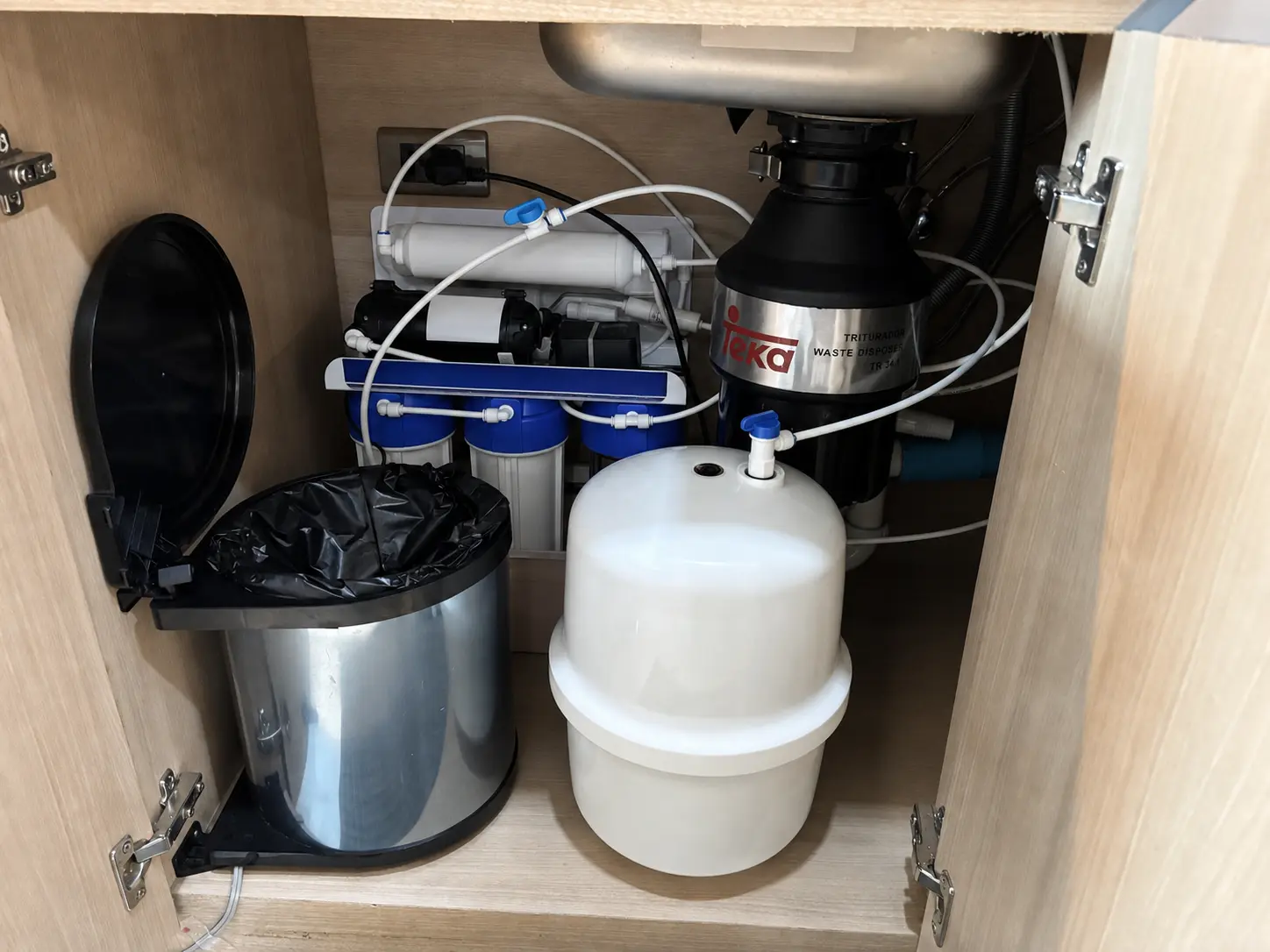 収納設備に合わせて配置したキッチン用RO浄水器本体と貯水タンク